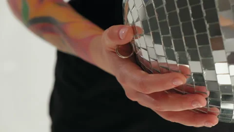 A girl with dreadlocks is standing in a white studio with a disco ball Stock Footage 183985637