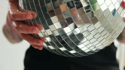 A girl with dreadlocks is standing in a white studio with a disco ball Stock Footage 183987876