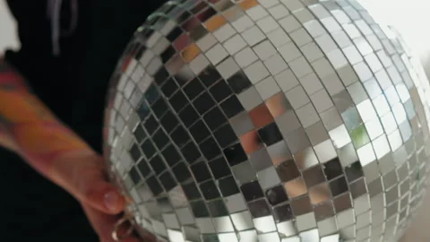 A girl with dreadlocks is standing in a white studio with a disco ball Stock Footage 183988008