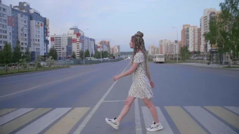 A girl with dreadlocks walking down a road Stock Footage 154722685