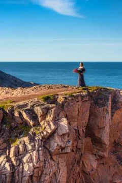 Girl in a dress on the edge of a cliff Stock Photos