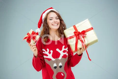 Girl dressed in santa hat with a Christmas gifts Stock Photos