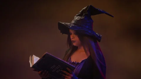 Girl Dressed as Witch Reading Spell Book for Halloween 스톡 동영상 341673464