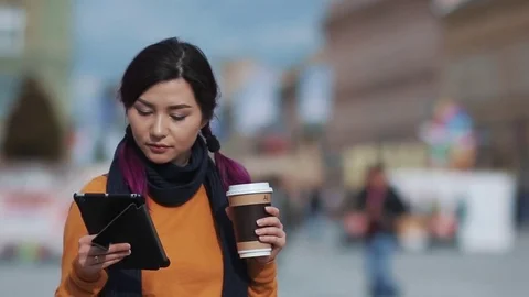 Girl drinking coffee and using phone in the street Video stock 70213900
