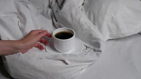 The girl is drinking coffee in bed. Interior. Cosiness. Video stock 159487984
