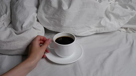 The girl is drinking coffee in bed. Interior. Cosiness. Video stock 159663351