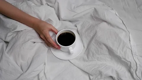 The girl is drinking coffee in bed. Interior. Cosiness. Video stock 159718444