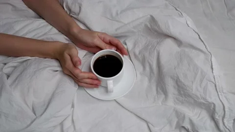 The girl is drinking coffee in bed. Interior. Cosiness. Video stock 159816410
