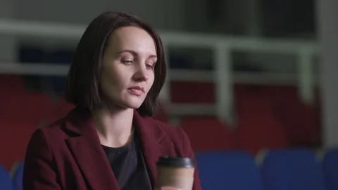 Girl drinking coffee at the stadium Stock Footage 118581653