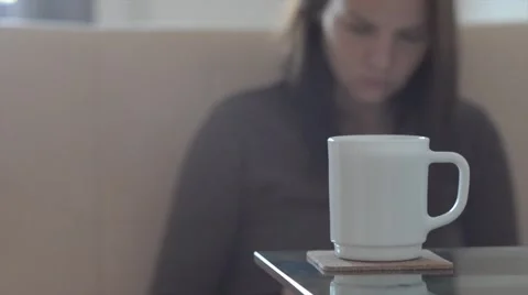 Girl drinking coffee tea and working with the tablet reading a book. At home. Stock Footage 61349986