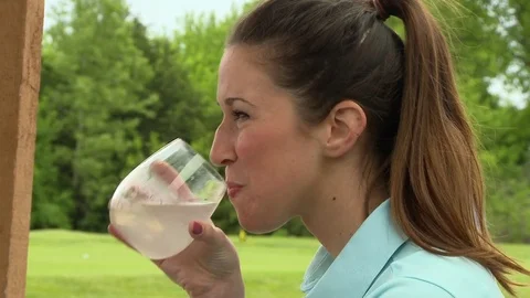 Girl drinking at golf course Stock Footage 74237978