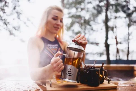 Girl drinking hot tea while sitting in the winter outside hot spa Stock Photos
