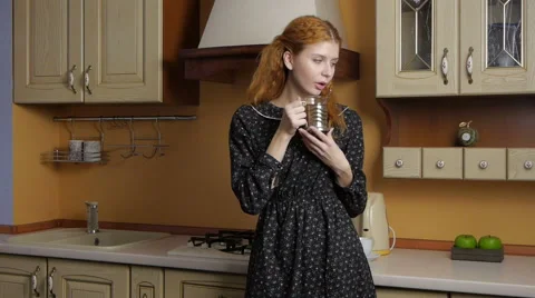 Girl drinking tea in the kitchen and dreams Stock-Footage 46146801