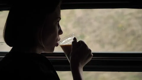 Girl drinking tea standing by the window in a train compartment.  Stock Footage 272292207