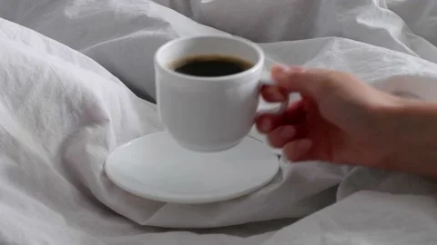 The girl drinks black coffee in bed. Breakfast in bed. Cosiness. Interior. Stock Footage 158691069