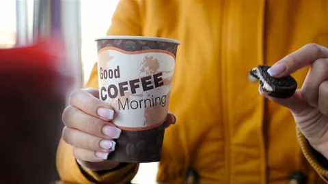 Girl drinks coffee and eats cookies. Close-up. Slow motion Stock Footage 117476548