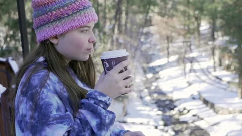 Girl drinks coffee overlooking stream Video stock 168489750