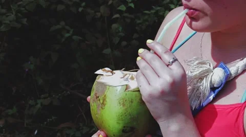 Girl drinks fresh coconut milk on the street in India Stock Footage 59794866