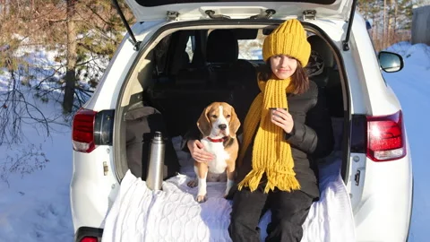 A girl drinks hot tea while sitting in the trunk of a car Stock Footage 294847144
