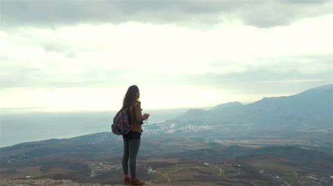 Girl  drinks water from a bottle on the background the mountains Stock Footage 59082234