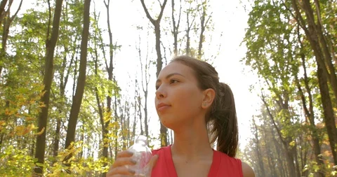 Girl drinks water while jogging in the morning. training. jogging. master shot Stock Footage 118594917