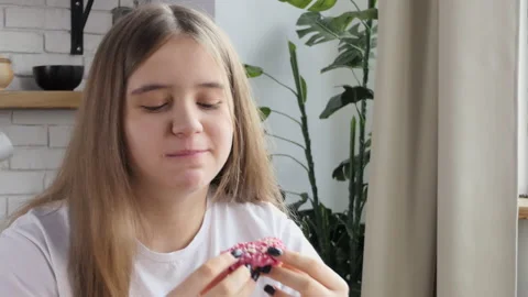 A girl with an eating disorder quickly eats a donut. The schoolgirl eats a donut Stock Footage 235908791