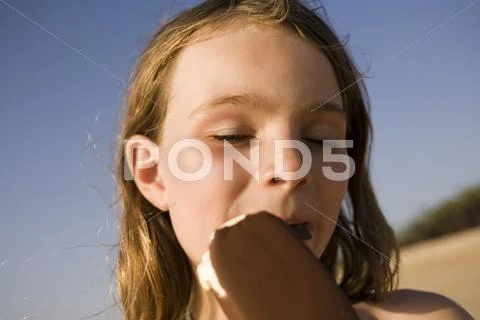 A Girl Eating An Ice Cream Bar