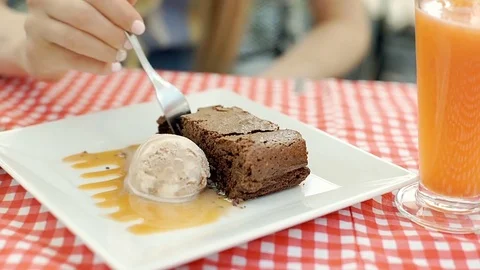 Girl eating tasty ice creams with brownie in the cafe, steadycam shot Stock Footage