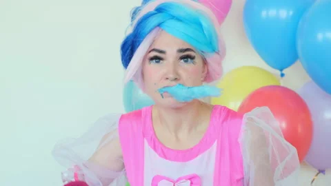 Girl eats blue cotton candy entertaining kids at birthday Видео 137568974