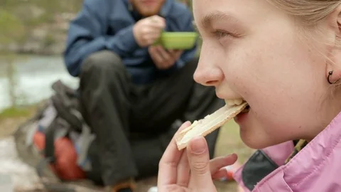 Girl eats bread and butter outdoors Stock Footage 72506733