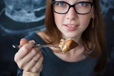 Girl eats cake by fork Stock Photos