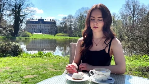 A girl eats a cake in the park Stock Footage 240547391