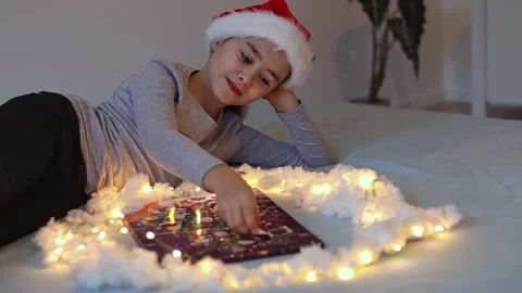 The girl eats a candy from the advent calendar. Stock Footage 253513386
