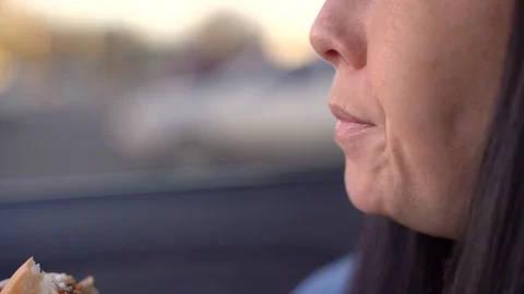 Girl eats a cheeseburger in a car Stock Footage 128082254
