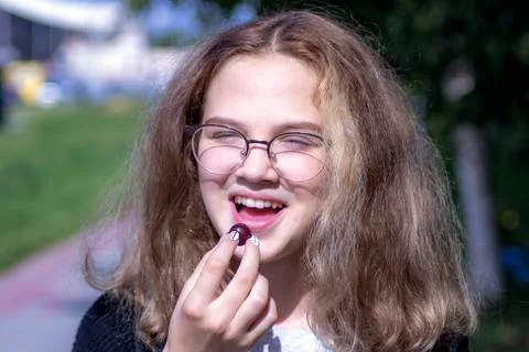The girl eats a cherry. Stock Photos