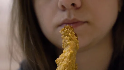 Girl eats chicken wing in batter Stock Footage 114753949