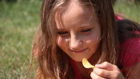 Girl eats chips on nature Stock Footage 80446678