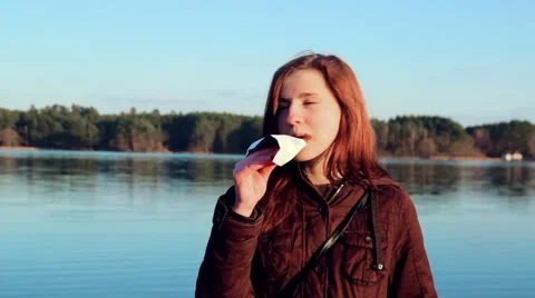 Girl eats chocolate at river with fun Stock Footage 61023028