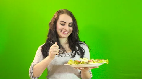 Girl eats on a green background 4K Stock Footage 61788874