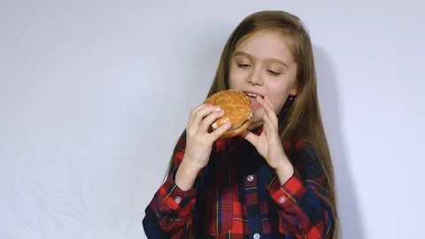 The girl eats a hamburger with pleasure Stock Footage 102453513