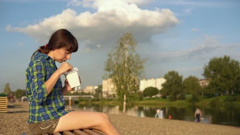 Girl eats hot noodles on pebble beach Stock Footage 115908055