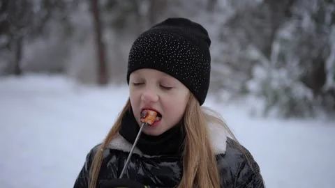 Girl eats marshmallows outdoors. Concept of sweet pleasure. Stock Footage 279512774