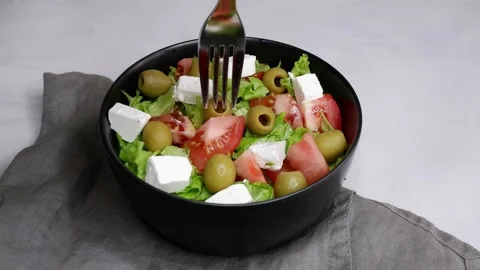 The girl eats olives from a bowl of salad. Food. Stock Footage 157444217