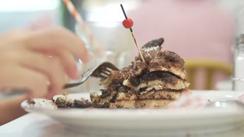 A girl eats pancakes with chocolate on plates Stock Footage 249599555