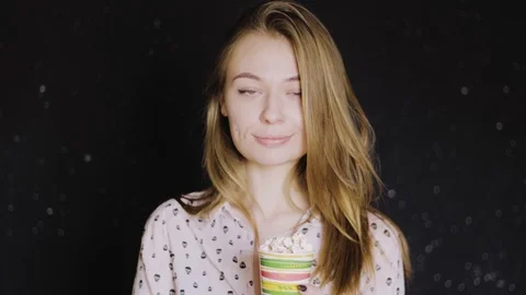 The girl eats popcorn from a paper cup. She is beautiful and nice. 4k Видео 88913699
