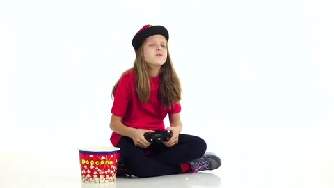 Girl eats popcorn, plays joystick in online game. Slow motion Stock Footage 75928985