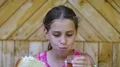 Girl eats slice of bread and washes down tea HD Footage