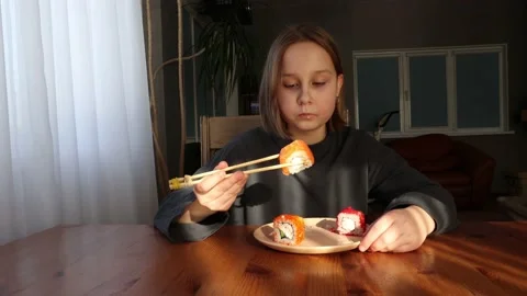 Girl eats sushi, rolls at the table Stock Footage 151445957