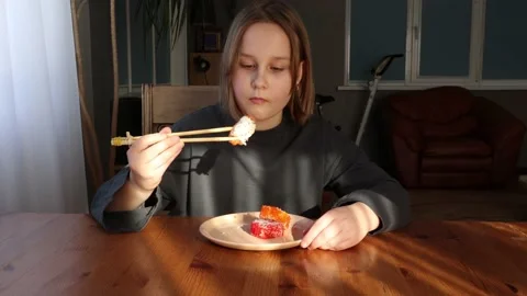 Girl eats sushi, rolls at the table Stock Footage 151445966
