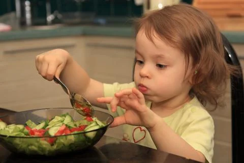 A girl eats vegetable salad. Fotos Stock